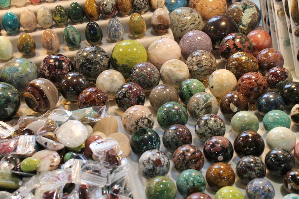 Many colorful spheres and eggs made of stone.